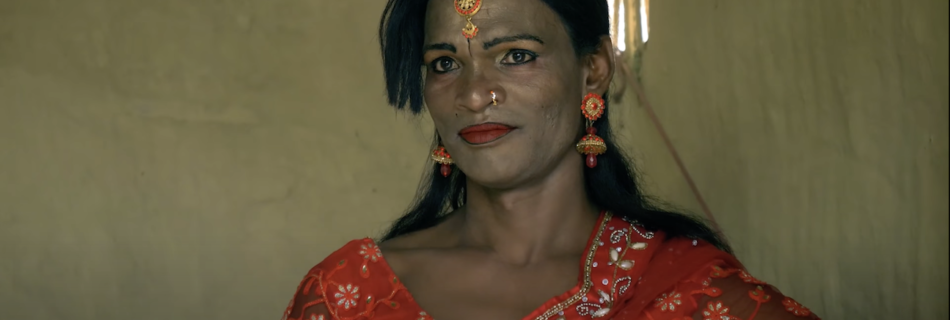 a person in a red saree smiling in front of the camera