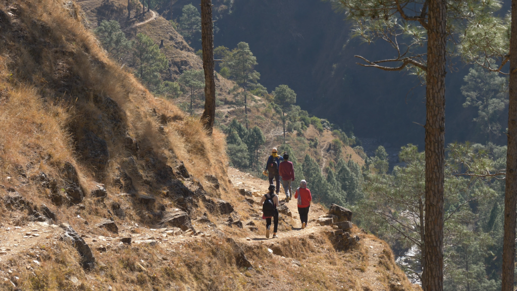 four people walking along the side of a hill