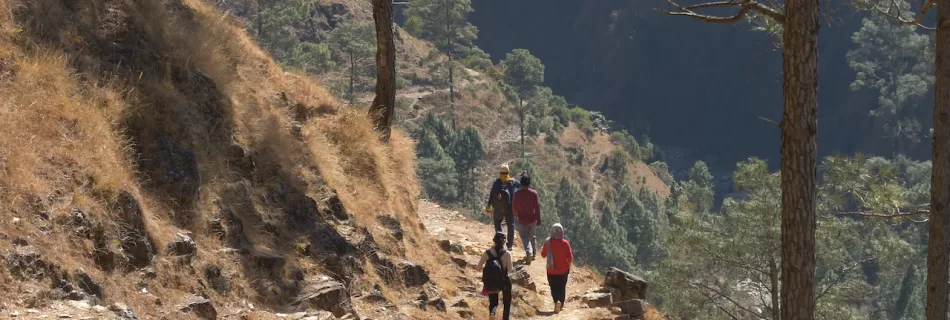 People walking along the side of a hill
