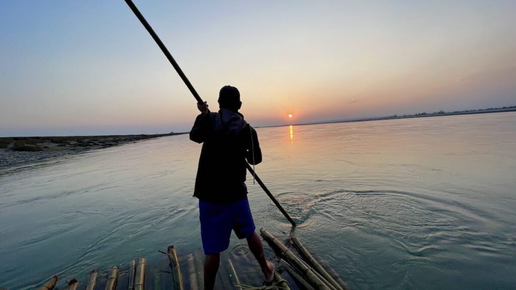 Story of Chefa - Picture shows a man rowing a bamboo raft on a river